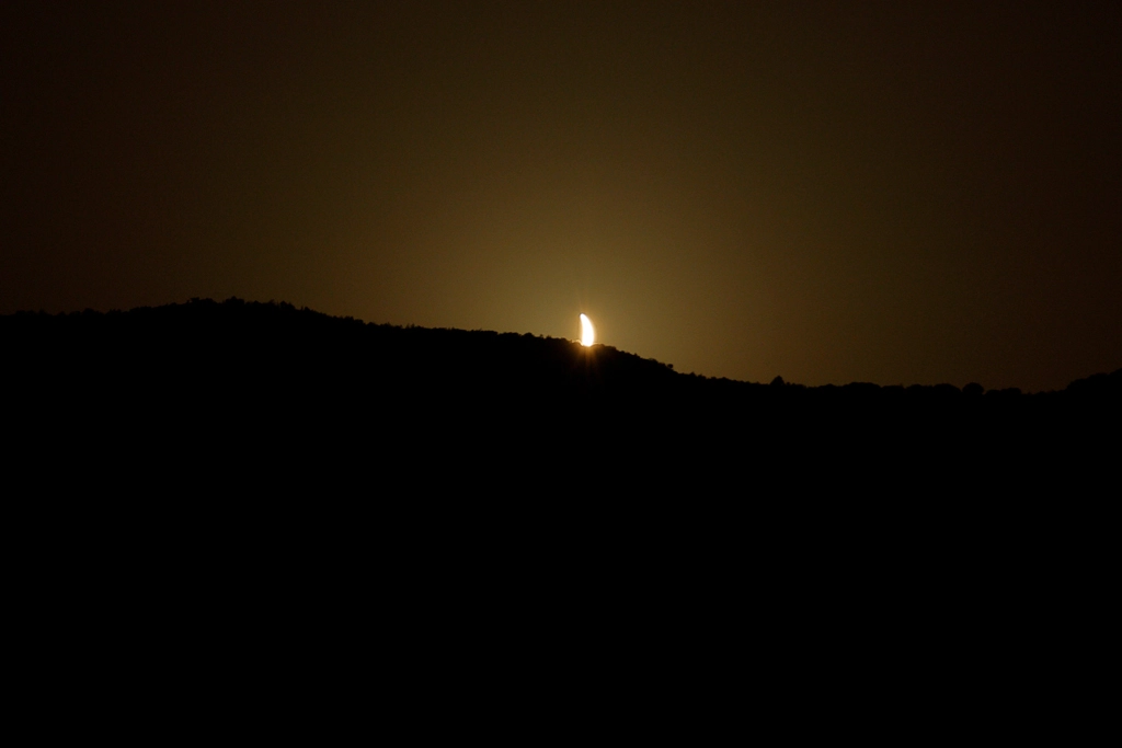 The solar eclipse disappears behind the mountains